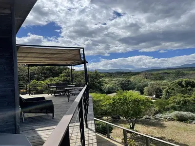 a balcony of a house with chairs and tables at A Casuccia in Zonza