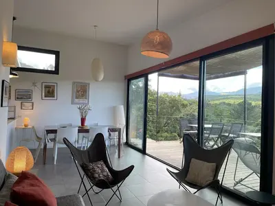 a living room with chairs and a table and a balcony at A Casuccia in Zonza