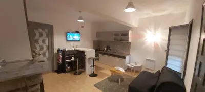 a living room with a couch and a desk at F2 Les Figuiers proche Ajaccio in Sarrola-Carcopino