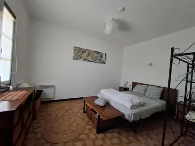 a bedroom with a bed and a table in it at F2 Les Figuiers proche Ajaccio in Sarrola-Carcopino