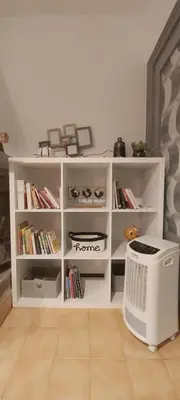 a white book shelf with a heater in a room at F2 Les Figuiers proche Ajaccio in Sarrola-Carcopino