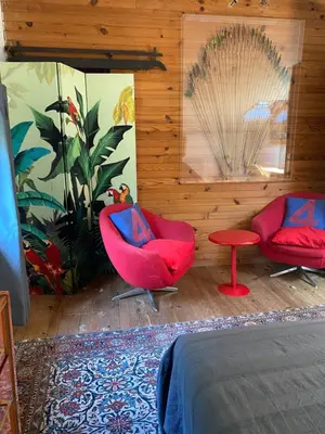 a bedroom with two red chairs and a table at Appartement cosy Vico in Vico