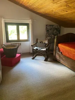 a bedroom with a bed and a chair and a window at Appartement cosy Vico in Vico