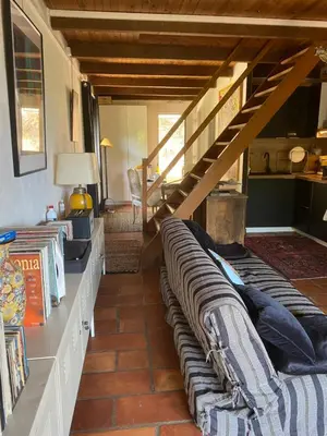 a living room with a couch and a staircase at Appartement cosy Vico in Vico