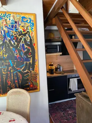 a room with a painting on the wall and a kitchen at Appartement cosy Vico in Vico