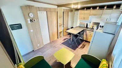 a small room with a kitchen with a table and chairs at Chalet V tout confort proche des plages in Pianottoli-Caldarello