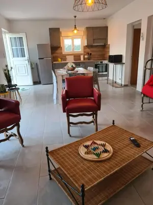 a living room with a table and a kitchen at Appartement confort in Île de Diane