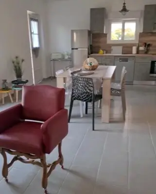 a kitchen with a red chair and a table in it at Appartement confort in Île de Diane