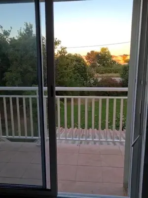 a view of a balcony from a sliding glass door at Appartement confort in Île de Diane