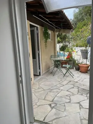 an open door to a patio with a table at olmareddu in Alata