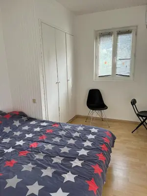 a bedroom with a red white and blue bed with a chair at olmareddu in Alata