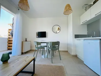 a kitchen and dining room with a table and chairs at Appt Lumineux pieds dans l'eau N181 in Linguizzetta