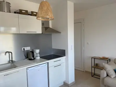 a kitchen with white cabinets and a counter top at Appt Lumineux pieds dans l'eau N181 in Linguizzetta