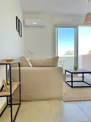 a living room with a couch and a table at Appt Lumineux pieds dans l'eau N181 in Linguizzetta