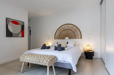 a bedroom with a large white bed and a bench at Le Calypso B01 - Climatisé avec vue mer in Grosseto-Prugna