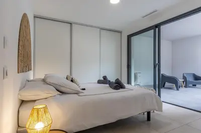 a bedroom with a large bed and glass walls at Le Calypso B01 - Climatisé avec vue mer in Grosseto-Prugna