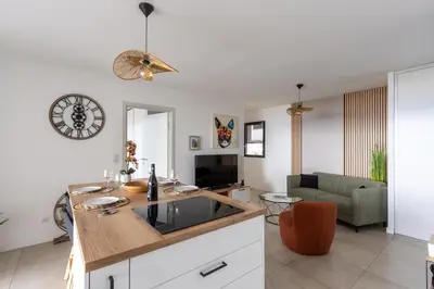 a kitchen and living room with a clock on the wall at Le Calypso B01 - Climatisé avec vue mer in Grosseto-Prugna