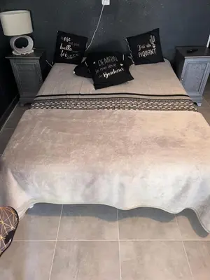 a bed in a bedroom with a tan bedspread at Appartements Luccisano in Borgo