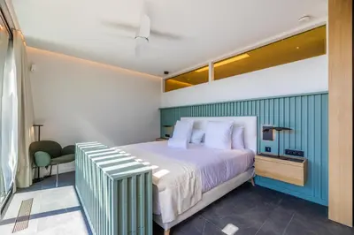a bedroom with a bed and a green wall at Hôtel VILLA MAIER in Sainte-Lucie de Porto-Vecchio