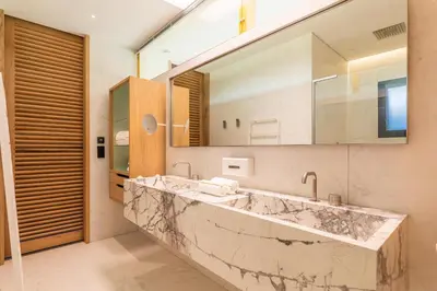 a bathroom with a large marble sink and a mirror at Hôtel VILLA MAIER in Sainte-Lucie de Porto-Vecchio