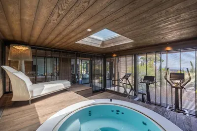 a room with a hot tub in a room with windows at Hôtel VILLA MAIER in Sainte-Lucie de Porto-Vecchio