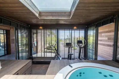 an indoor gym with a hot tub and exercise equipment at Hôtel VILLA MAIER in Sainte-Lucie de Porto-Vecchio