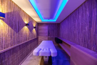 a purple bathroom with a bench and a blue light at Hôtel VILLA MAIER in Sainte-Lucie de Porto-Vecchio
