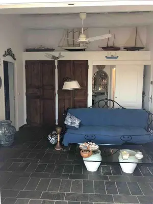 a living room with a blue couch in a house at Casetta indipendente con vista a Santa Giulia in Porto-Vecchio