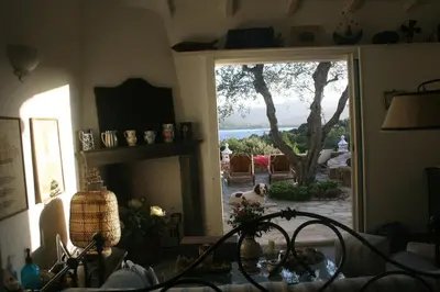 a living room with a door to a patio with a dog at Casetta indipendente con vista a Santa Giulia in Porto-Vecchio