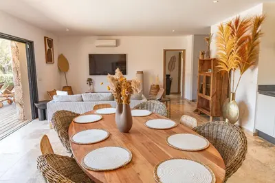 a table with plates and chairs in a living room at Villa Campemu Di Lecci in Lecci