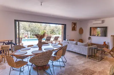 a living room with a table and chairs and a couch at Villa Campemu Di Lecci in Lecci