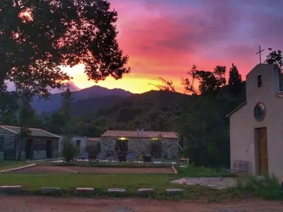 a church with a sunset in the background at Bergerie du Prunelli in Cauro