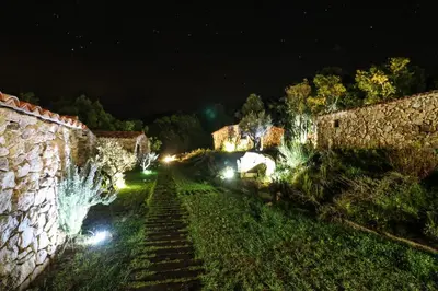 a view of a yard at night with lights at Bergerie du Prunelli in Cauro