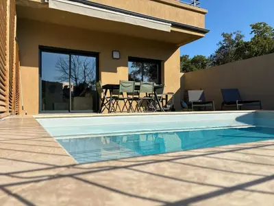 a swimming pool in front of a house at Villa Lagon Bleu- Piscine privée- Corsu di Core in Favone