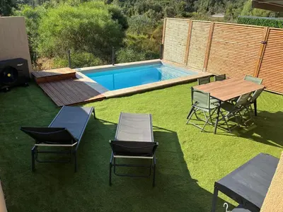 a backyard with a table and chairs and a pool at Villa Lagon Bleu- Piscine privée- Corsu di Core in Favone