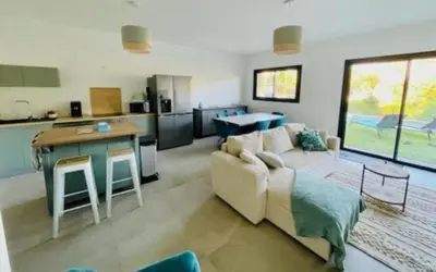 a living room with a couch and a kitchen at Villa Lagon Bleu- Piscine privée- Corsu di Core in Favone