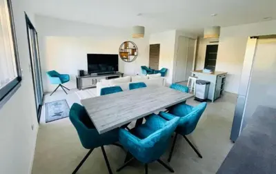 a living room with a wooden table and blue chairs at Villa Lagon Bleu- Piscine privée- Corsu di Core in Favone