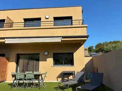a building with a table and chairs in front of it at Villa Lagon Bleu- Piscine privée- Corsu di Core in Favone