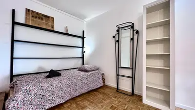 a bedroom with a bed in a room with shelves at Coliving Ajaccio in Ajaccio