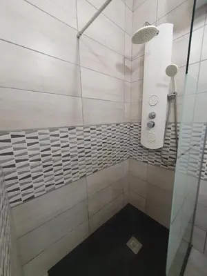 a bathroom with a shower with white tiles at studio cosy idéalement situé parking privé in Ajaccio