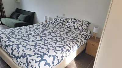 a bedroom with a bed with a black and white comforter at Résidence Dolce Vita in Propriano