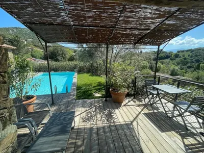 a patio with a table and chairs and a swimming pool at A Casetta Di Oletta in Oletta