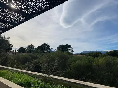 a view of a field from under a bridge at T3 Tout confort à 5 mn des plages de Pinarello in Pinarellu