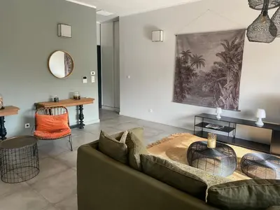 a living room with a couch and a table at T3 Tout confort à 5 mn des plages de Pinarello in Pinarellu