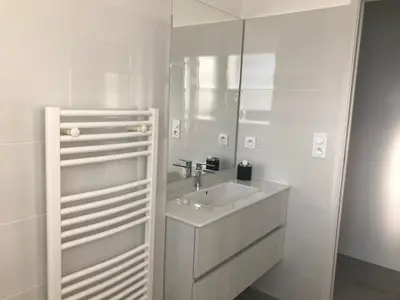 a white bathroom with a sink and a mirror at T3 Tout confort à 5 mn des plages de Pinarello in Pinarellu