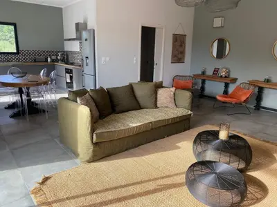 a living room with a couch and a kitchen at T3 Tout confort à 5 mn des plages de Pinarello in Pinarellu