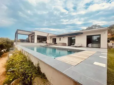 a bedroom with a white bed with towels on it at Architect's Villa - 10-12 people - Pool - 4 bedrooms in Zonza