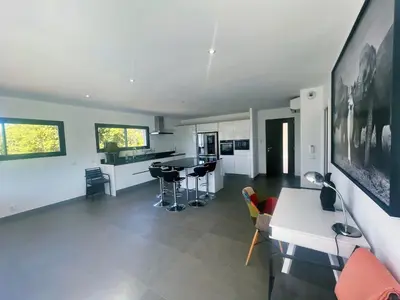 a kitchen and living room with a table and chairs at Architect's Villa - 10-12 people - Pool - 4 bedrooms in Zonza