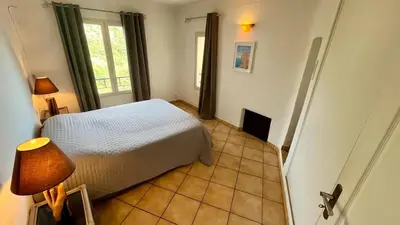 a bedroom with a bed and a tiled floor at Villa Porra 100m2, pleine nature, piscine, vue mer in Porto-Vecchio