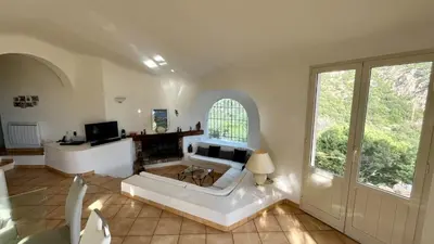 a living room with a white couch and a fireplace at Villa Porra 100m2, pleine nature, piscine, vue mer in Porto-Vecchio